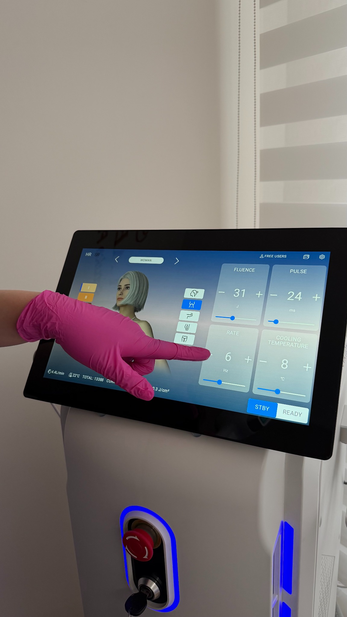 Obsługa lasera diodowego w Lublinie. Ręka w różowej rękawiczce ustawia parametry zabiegu na ekranie dotykowym urządzenia kosmetycznego.