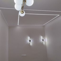 EL-KAR Karol Napora - Nowoczesne oświetlenie sufitowe z lampą kulistą i liniami LED tworzącymi geometryczny wzór. Dwa kinkiety ścienne o futurystycznym designie. Minimalistyczne wnętrze.