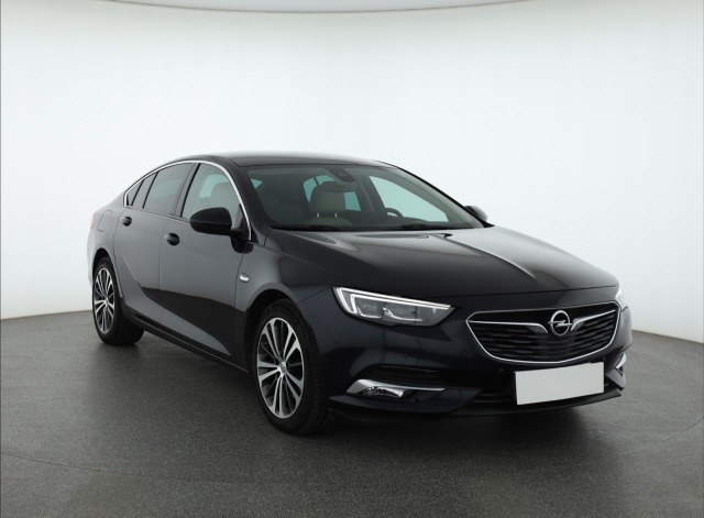 Czarna Opel Insignia, elegancki sedan z chromowanymi detalami, prezentowana na jasnym tle. Widoczne felgi aluminiowe i reflektory LED. Idealna do wynajmu.