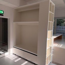 Formedge - Biała szafa wnękowa z półkami i szufladami, umieszczona w jasnym pomieszczeniu z oknem. Widoczne detale wykończenia i minimalistyczny design.