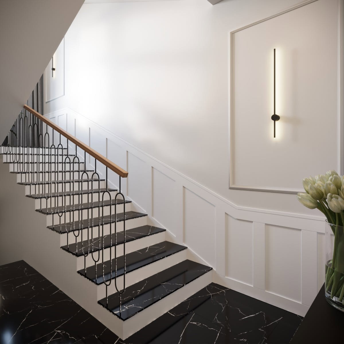 Nowoczesne schody z czarnym marmurem i metalową balustradą. Ściany wykończone białymi panelami i minimalistycznym oświetleniem. Wazon z tulipanami dodaje elegancji.