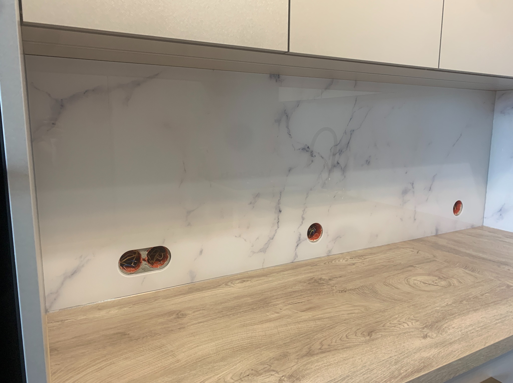 Szkło z grafiką 'marmur'. Widać również wycięcia na gniazdka.