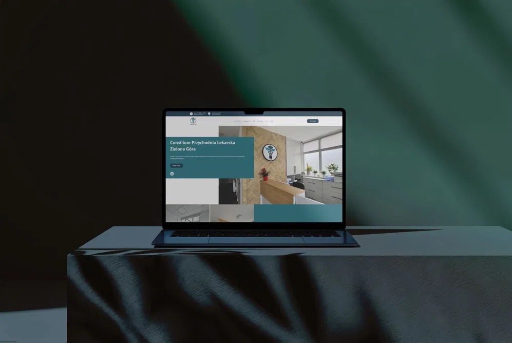 Laptop prezentuje stronę internetową przychodni lekarskiej z Zielonej Góry. Nowoczesny design, stonowana kolorystyka, widoczne logo i zdjęcia wnętrz.