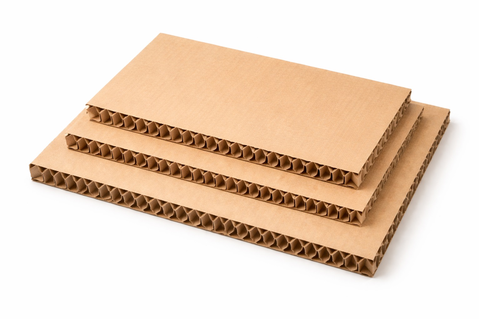 Trzy arkusze brązowej tektury falistej ułożone jeden na drugim, z widoczną strukturą fal. Czyste, białe tło podkreśla detale materiału.
