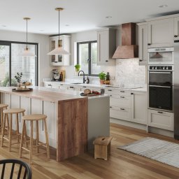 Michał Góral U3D - Jasna kuchnia z drewnianymi akcentami: wyspa z hokerami, marmurowy blat, miedziany okap, nowoczesne oświetlenie i widok na ogród przez przesuwne drzwi.