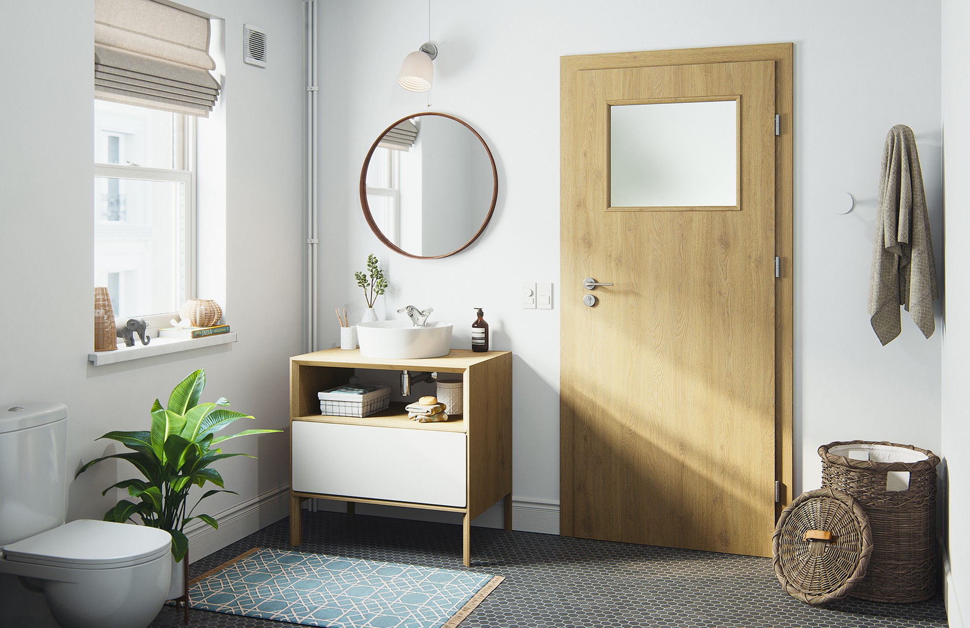 Jasna łazienka z drewnianą szafką pod umywalką, okrągłym lustrem i drzwiami z przeszkleniem. Na podłodze heksagonalne płytki i błękitny dywanik.