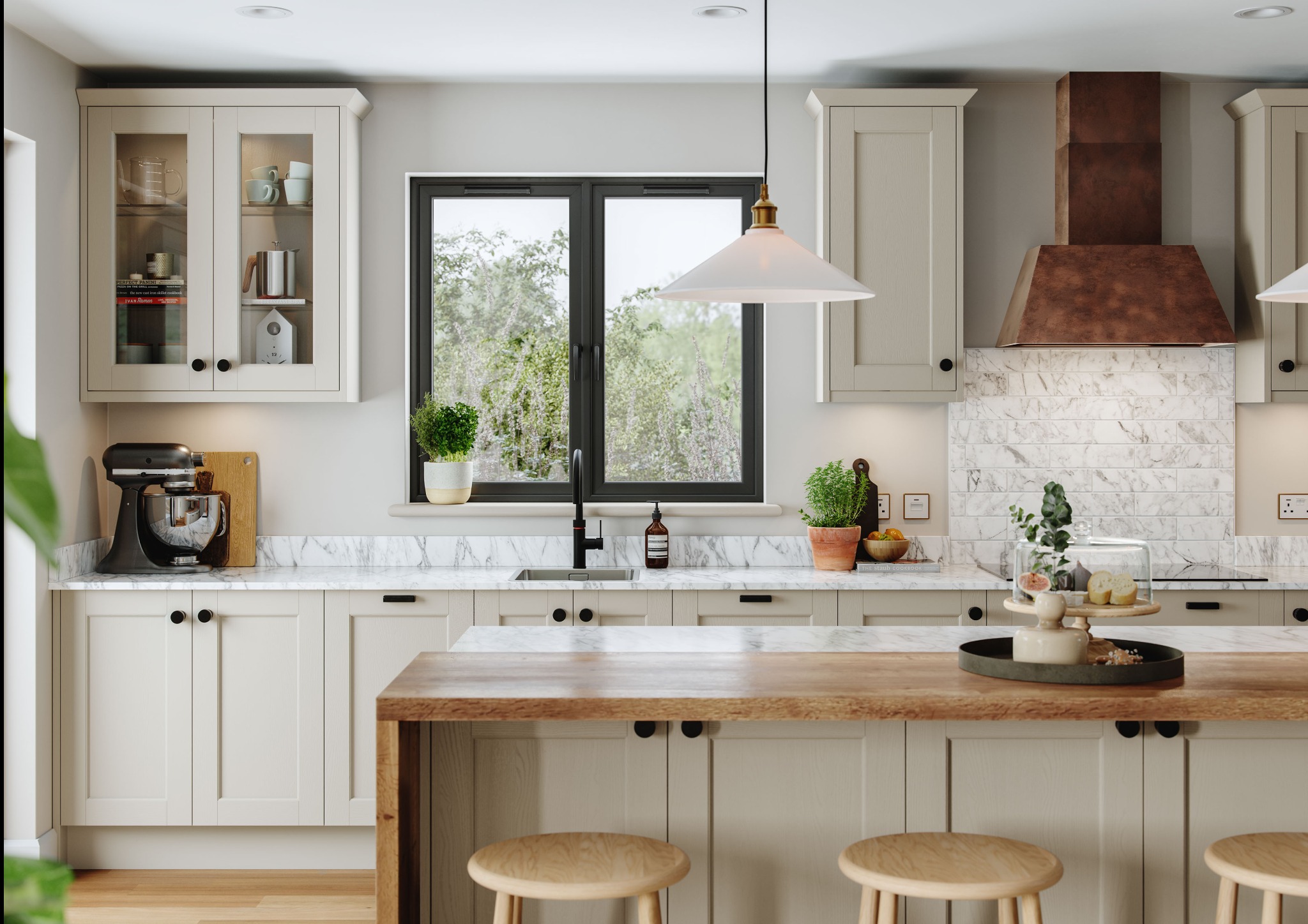 Jasna kuchnia w stylu klasycznym z marmurowym blatem, drewnianym barkiem i czarnymi akcentami. Widok na okno z zielenią. Na blacie dekoracje i owoce pod kloszem.