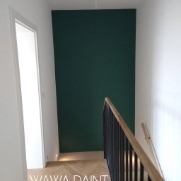 VLADLEN HRYBACHOV - Klatka schodowa po malowaniu: ściana w odcieniu butelkowej zieleni kontrastuje z bielą ścian i stolarki. Parkiet ułożony we wzór jodełki. Balustrada z drewnianym pochwytem.