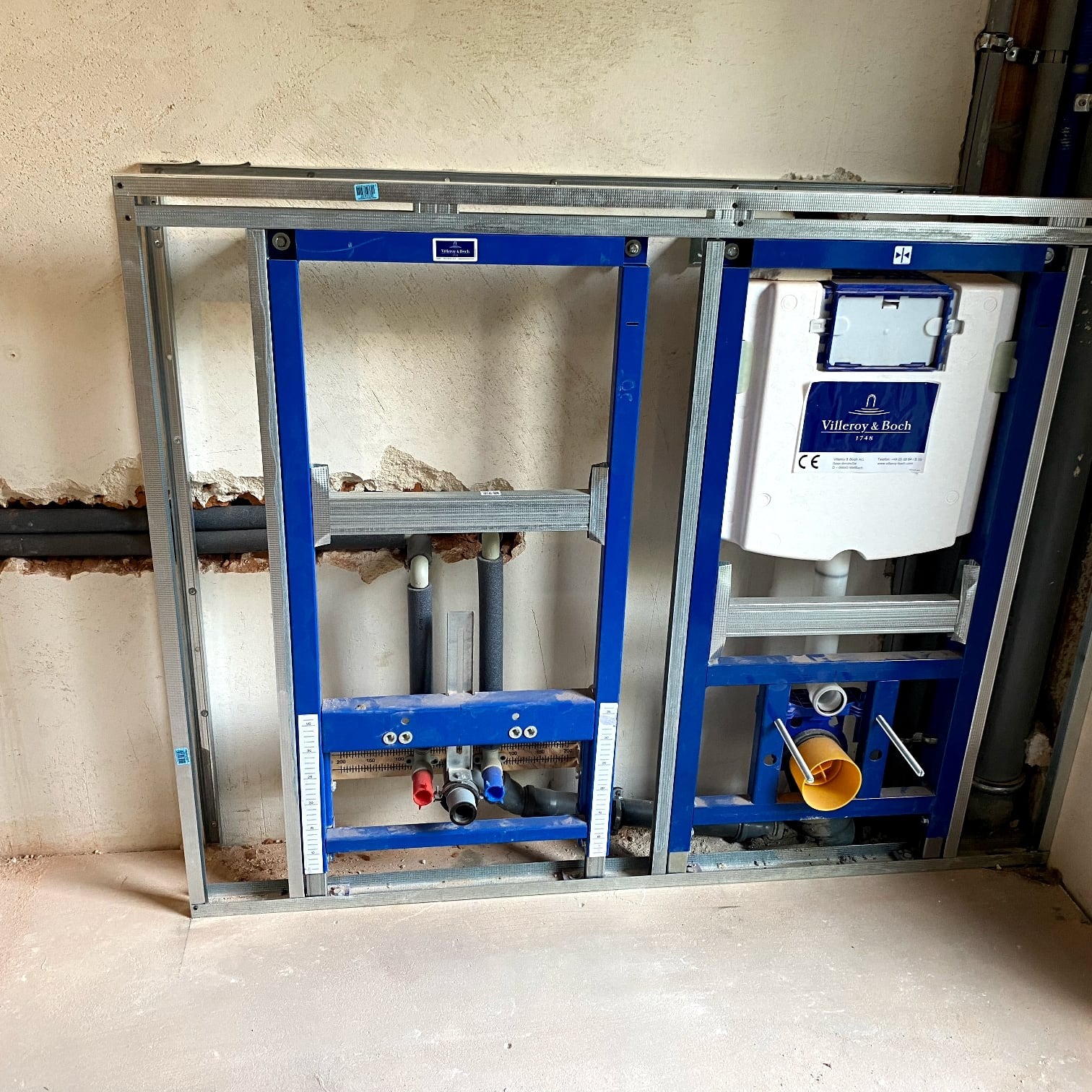 Stelaż podtynkowy Villeroy & Boch zamontowany w surowej łazience, widoczne rury i instalacja wodno-kanalizacyjna przed zabudową.