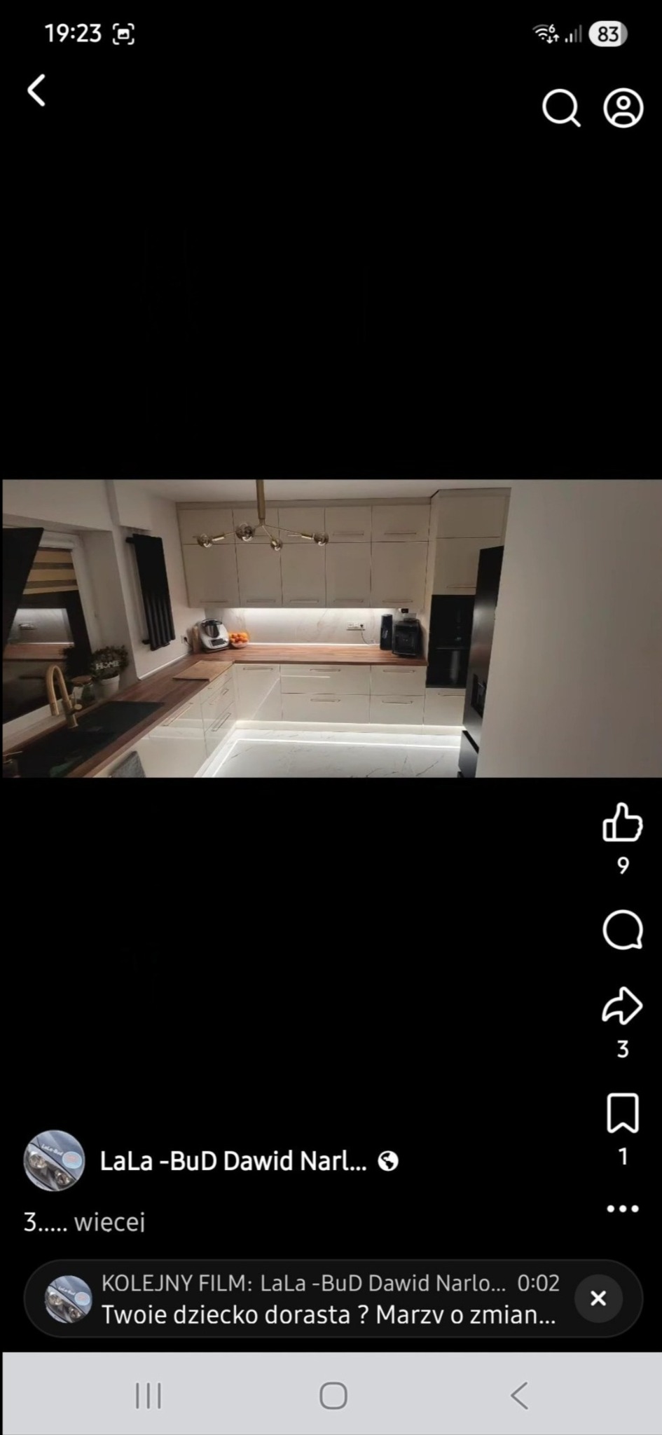 Nowoczesna kuchnia w jasnych barwach z drewnianym blatem i oświetleniem LED pod szafkami. Widoczny zlew z złotą baterią i czarna lodówka.