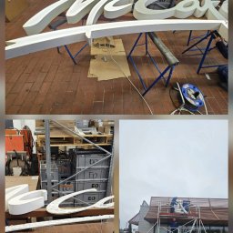 Elektro-Tech - Montaż przestrzennego napisu reklamowego na elewacji budynku. Prace na rusztowaniu, widoczne elementy konstrukcyjne i narzędzia. Etap instalacji.