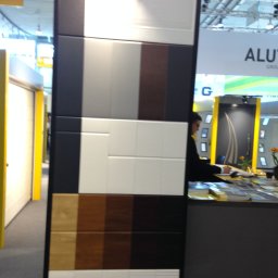 SOLID OKNA - Ekspozycja paneli drzwiowych w Katowicach: różne kolory i faktury, od białych po drewnopodobne, prezentowane na czarnym stelażu. Widoczny fragment stoiska targowego.