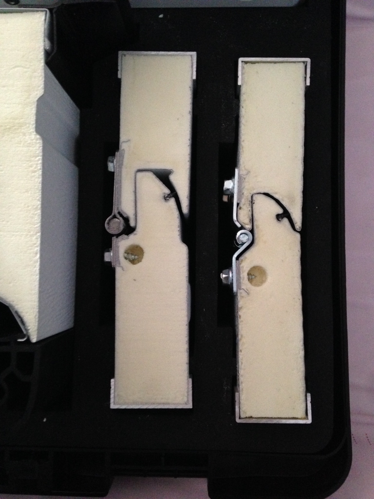 Przekrój paneli z pianki poliuretanowej z metalowymi elementami mocującymi, widoczne detale łączenia. Prezentacja budowy i izolacji.