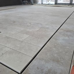 Dno basenu oraz plazą wykonczona kamieniem naturalnym tutaj Trawertyn selekcjonowany