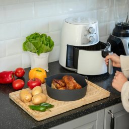 SARA STUDIO - Frytkownica beztłuszczowa Delimano z kurczakiem w koszyku, obok warzywa: sałata, pomidory, papryka, ziemniaki, jalapeño. Przygotowanie posiłku w kuchni.