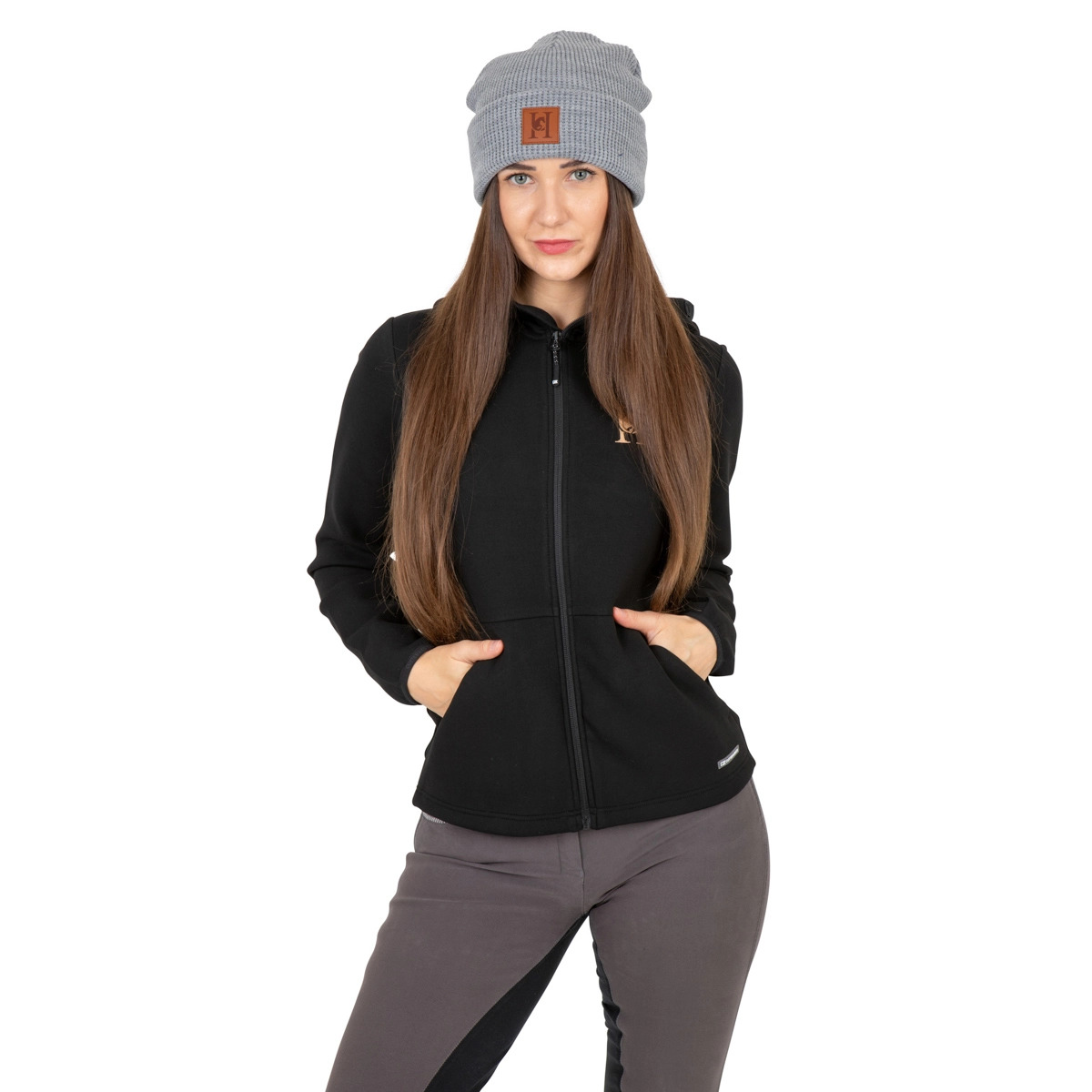 Modelka w szarej czapce i czarnej bluzie z kapturem, na białym tle. Ubrania z widocznym logo. Ujęcie centralne, oświetlenie studyjne, neutralny wyraz twarzy.