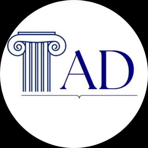 Eleganckie logo firmy z kolumną i inicjałami 'AD' w granatowej kolorystyce, umieszczone na białym tle w okręgu. Klasyczny i profesjonalny design.