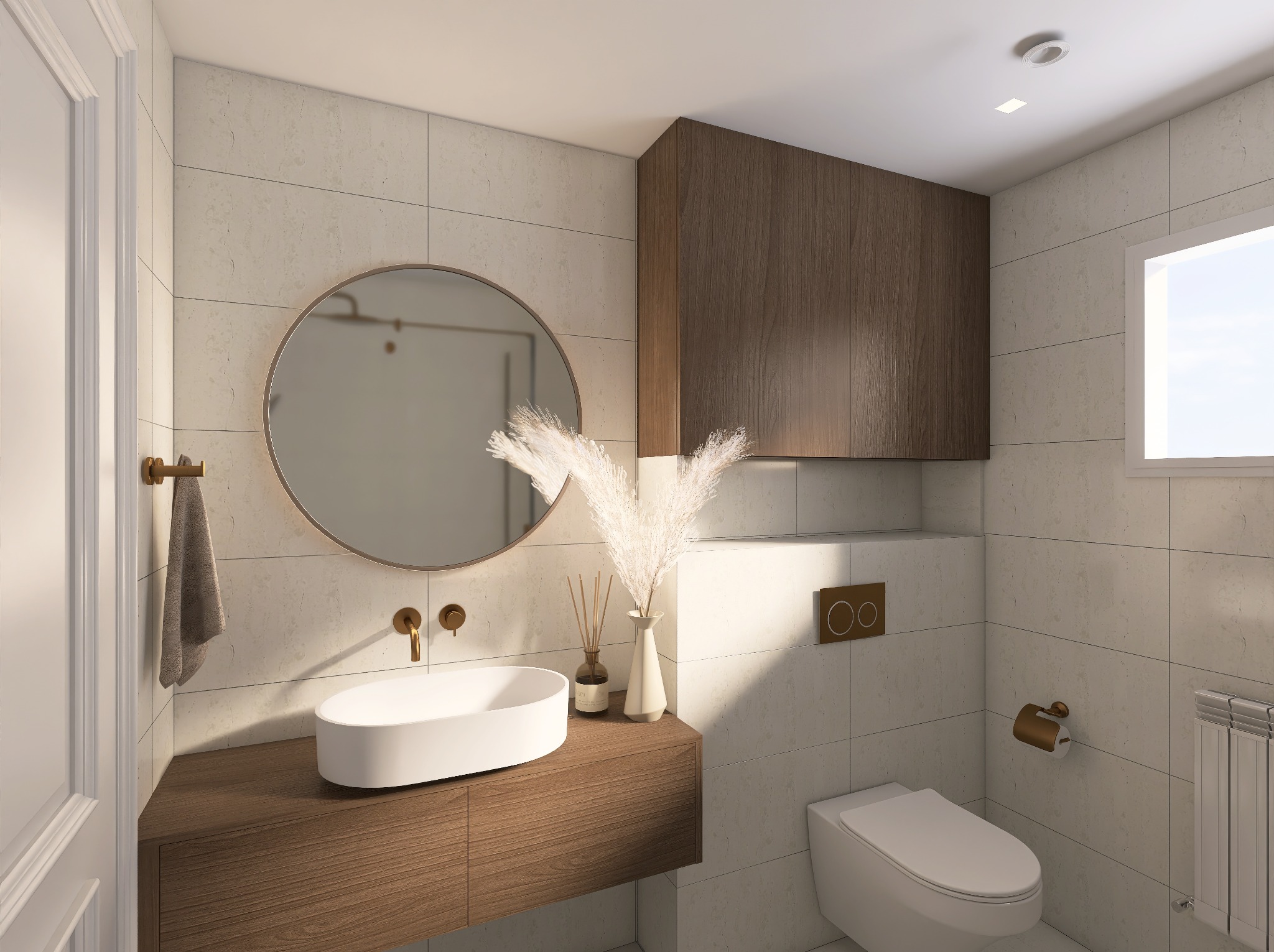 Nowoczesna łazienka z owalną umywalką, okrągłym lustrem i drewnianymi szafkami. Beżowe płytki, złote akcenty i dekoracyjne trawy pampasowe dodają elegancji.