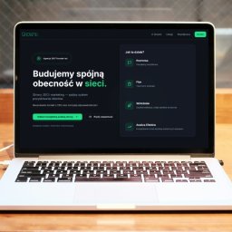 Growto - Laptop z otwartą stroną agencji Growto na drewnianym biurku. Widoczny kubek z kawą. Strona oferuje spójną obecność w sieci, analizę efektów i bezpłatną analizę strony.