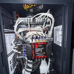 MICHAŁ Z NAPIĘCIEM MICHAŁ PAWLAK - Szafa rack z multiswitchem Opticum, patch panelem Getfort i okablowaniem. Widoczna lista obwodów: domofon, monitoring, rekuperacja, pokoje, salon, sypialnia.