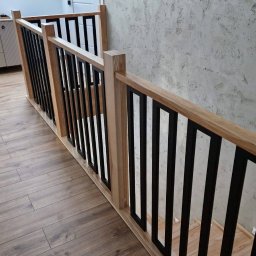 A.I.M Weld Usługi Spawalnicze MARIUSZ PARUZEL - Nowoczesna balustrada schodowa z jasnego drewna i czarnych, prostokątnych elementów, widok z góry, z elementami wystroju wnętrza w tle.