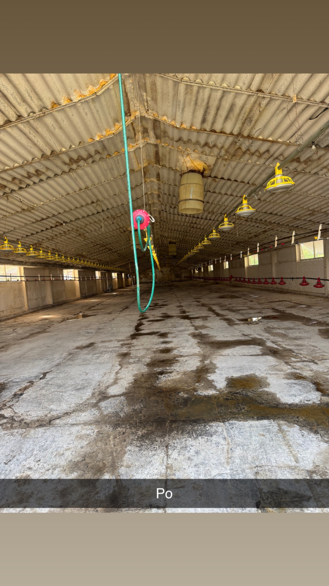 Wnętrze hali produkcyjnej z widocznymi śladami zabrudzeń na podłodze i suficie. Widoczne lampy i instalacje pod sufitem. Zdjęcie 'po' czyszczeniu.