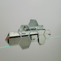 Fast Bilding Vasyl Voloshyn - Dekoracyjne lustra w kształcie plastra miodu na ścianie, odbijające wnętrze kuchni. Widoczna zielona linia lasera poziomującego.