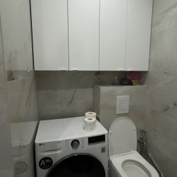 Fast Bilding Vasyl Voloshyn - Nowoczesna łazienka z marmurowymi płytkami, białą zabudową meblową, pralką LG i podwieszaną toaletą. Minimalistyczny design, stonowana kolorystyka.