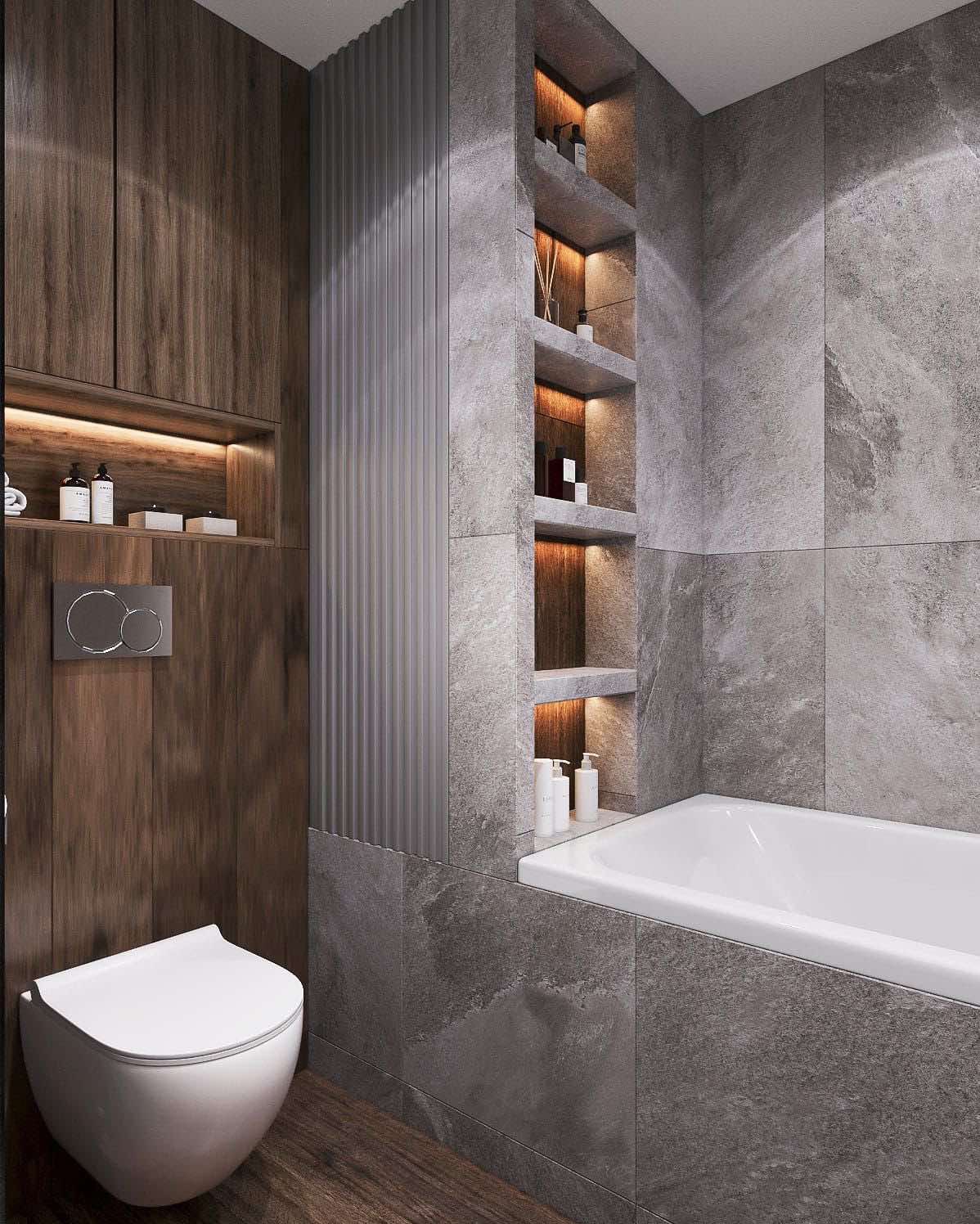 Nowoczesna łazienka z szarymi płytkami imitującymi kamień, drewnianymi szafkami z podświetlanymi półkami i wiszącą toaletą. Minimalistyczny design z akcentami światła.