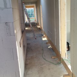 Kamil Chatya - Wnętrze w trakcie prac wykończeniowych: ściany z płyt gipsowo-kartonowych, widoczne profile i drabina. Surowy stan, przygotowanie do dalszych prac.