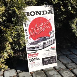 epomocdlaseciora - Plakat Honda NSX Takmashido Autos Deportivos, oparty o kostkę brukową i otoczony zielonymi gałązkami, prezentuje grafikę auta i japońskie napisy.