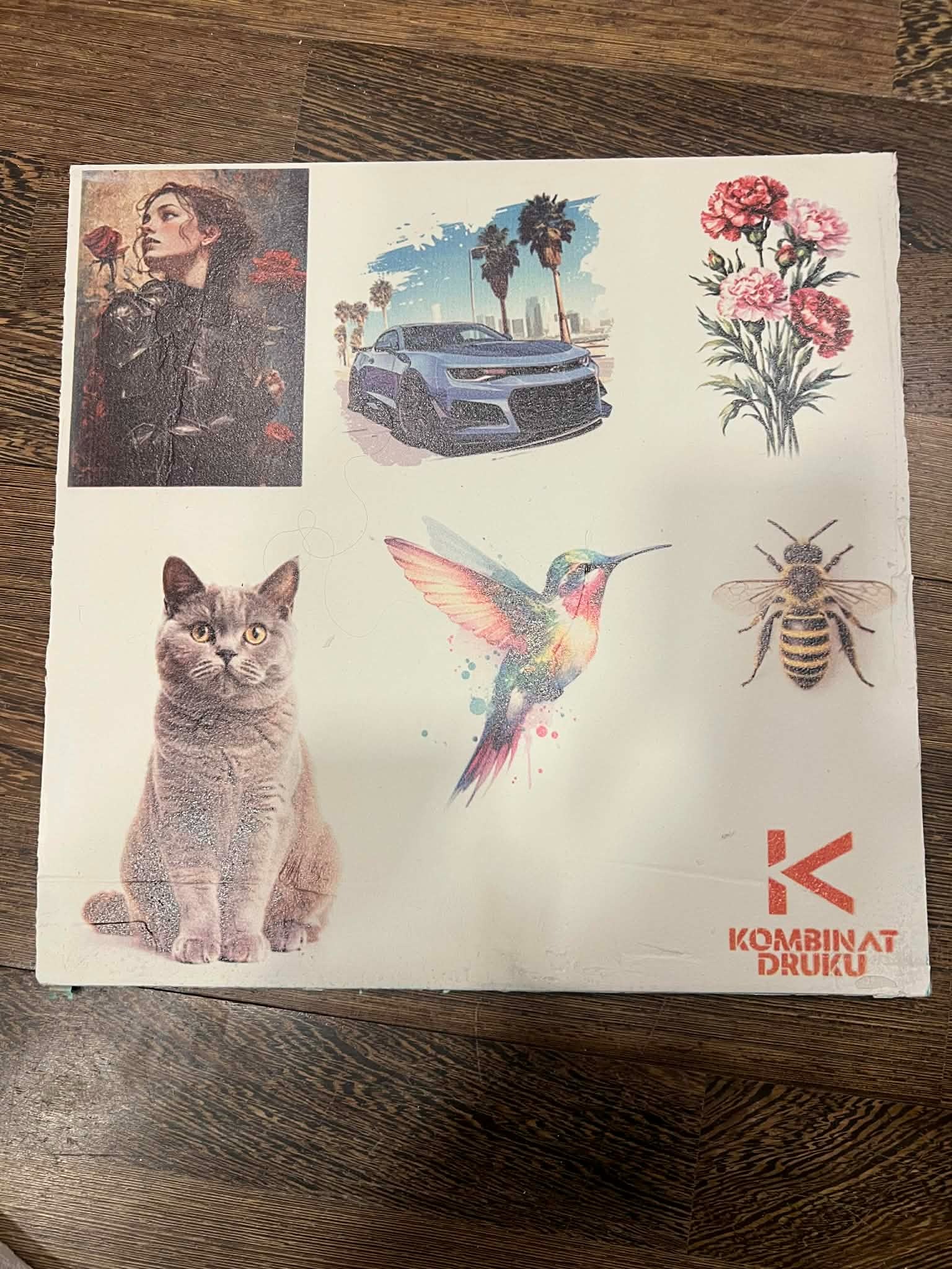 Kwadratowa płyta z nadrukowanymi różnorodnymi grafikami: kobieta z różą, auto, kwiaty, koliber, pszczoła i kot. Widoczne logo firmy drukarskiej.