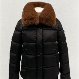 KM INVESTMENT POLAND PATRYK MIŁOSZ - Czarna, pikowana kurtka z brązowym futrzanym kołnierzem, prezentowana na manekinie w Radomiu. Elegancki fason, idealny na chłodniejsze dni. Detal: widoczne kieszenie.