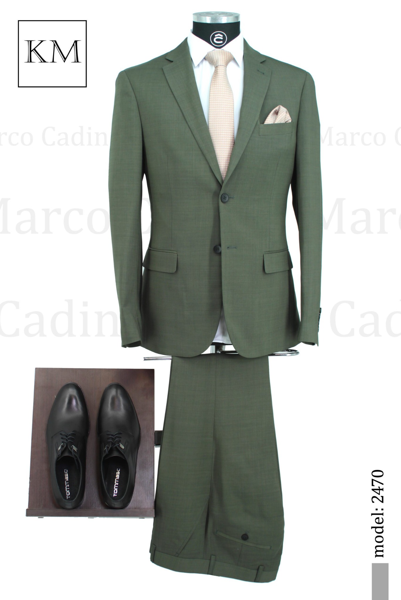 Elegancki, oliwkowy garnitur męski z poszetką i krawatem, prezentowany na manekinie z parą czarnych, skórzanych butów. Model 2470.