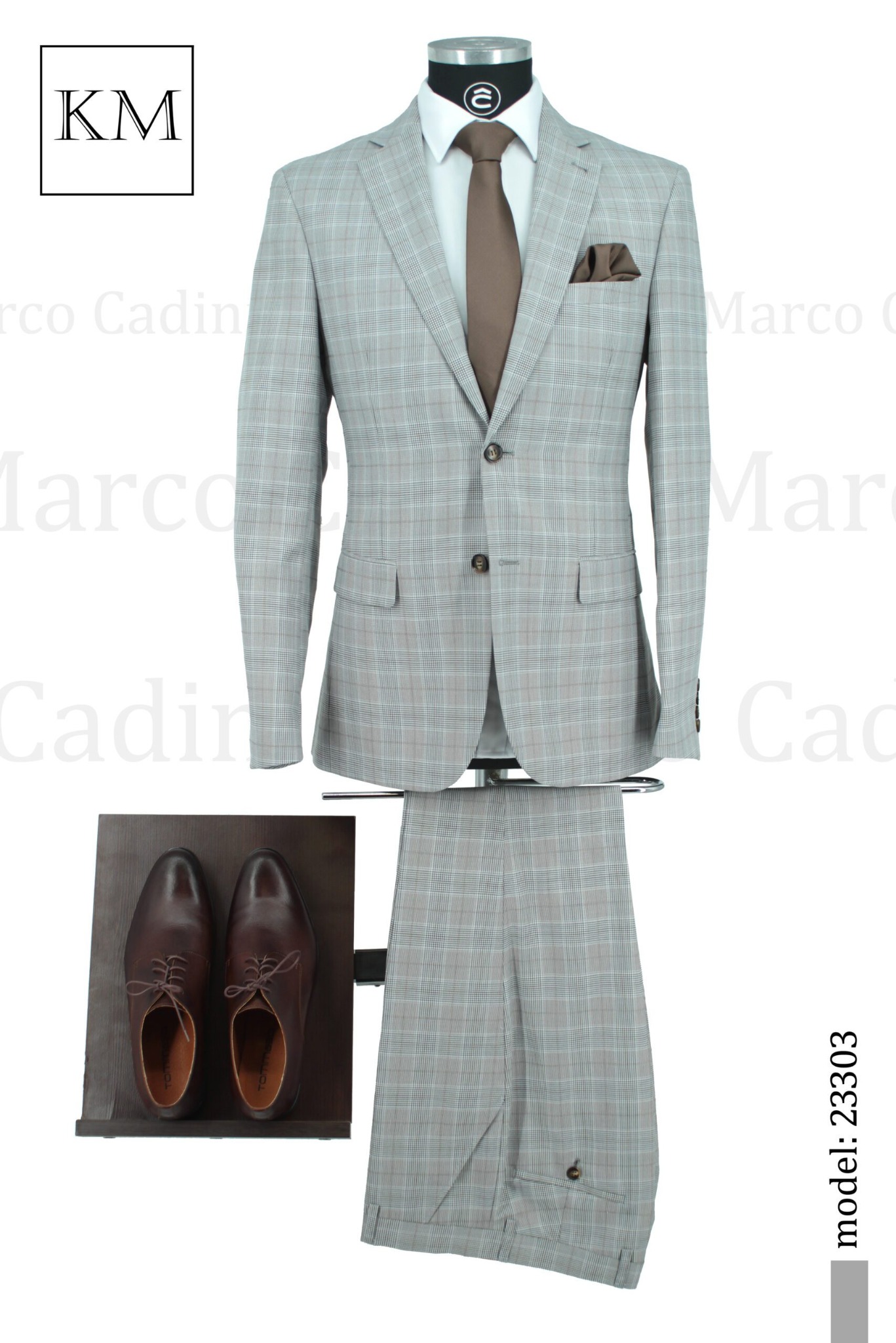 Elegancki, szary garnitur w kratę, z brązowym krawatem i poszetką, prezentowany na manekinie. Obok para brązowych, skórzanych butów. Model: 23303.