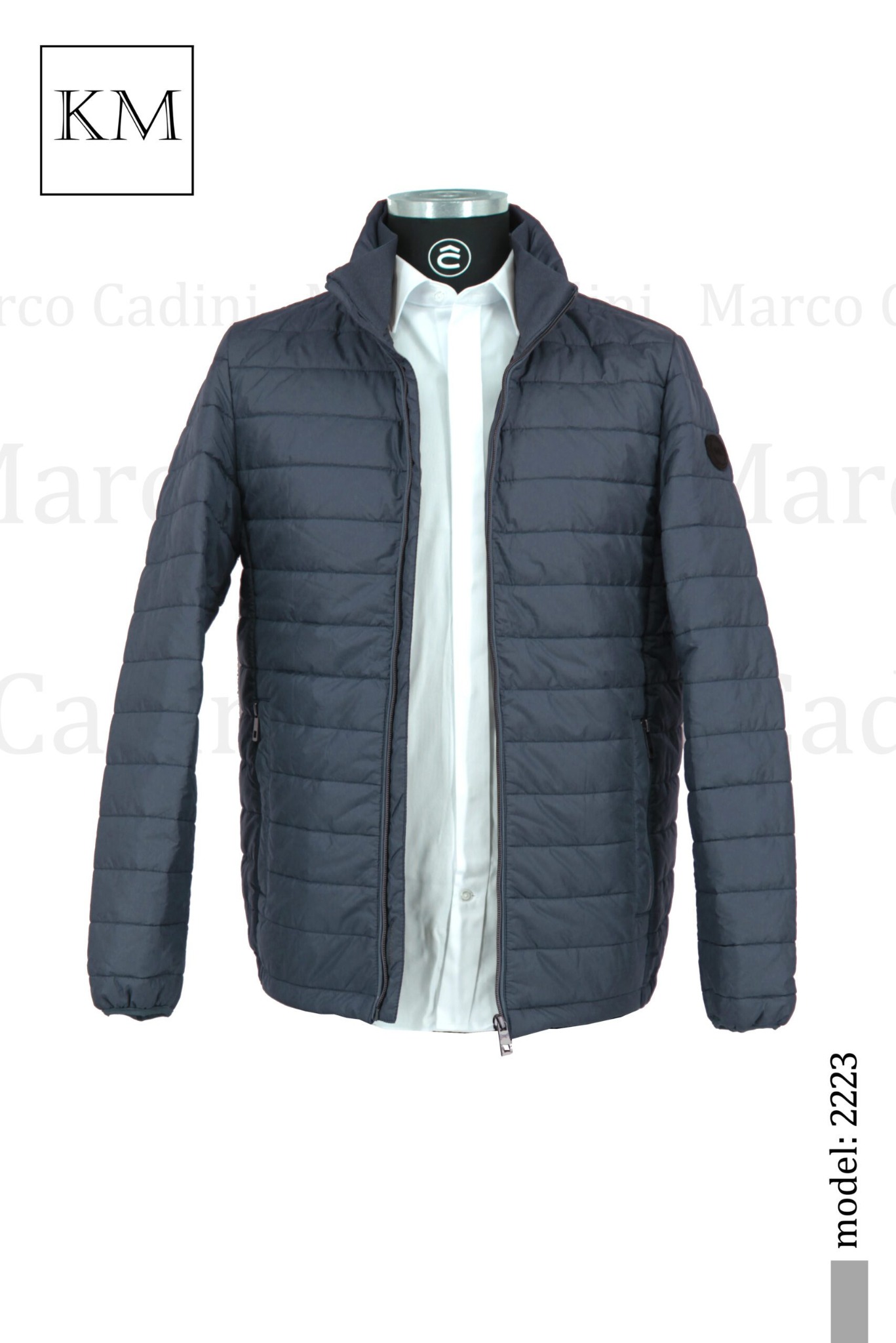 Niebieska, pikowana kurtka męska z rozpiętym zamkiem, prezentowana na manekinie z białą koszulą. Widoczny model: 2223. Stonowana kolorystyka i minimalistyczny design.