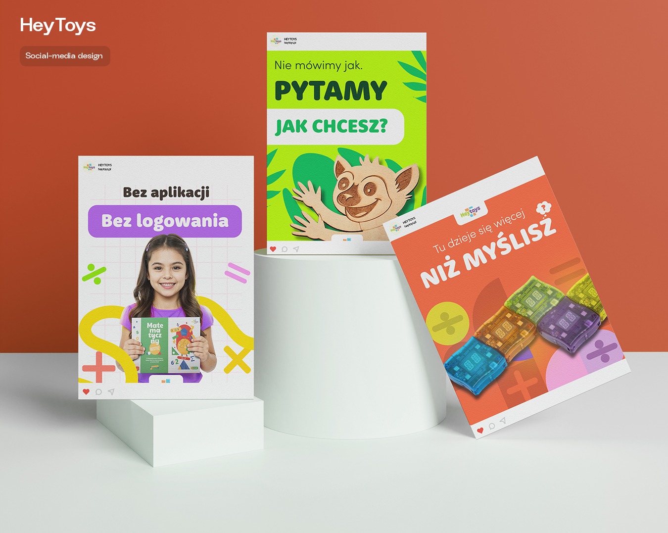 Social-media design: Trzy grafiki HeyToys na białych postumentach. Pierwsza z dziewczynką, druga z lemurem, trzecia z klockami. Pomarańczowe tło.
