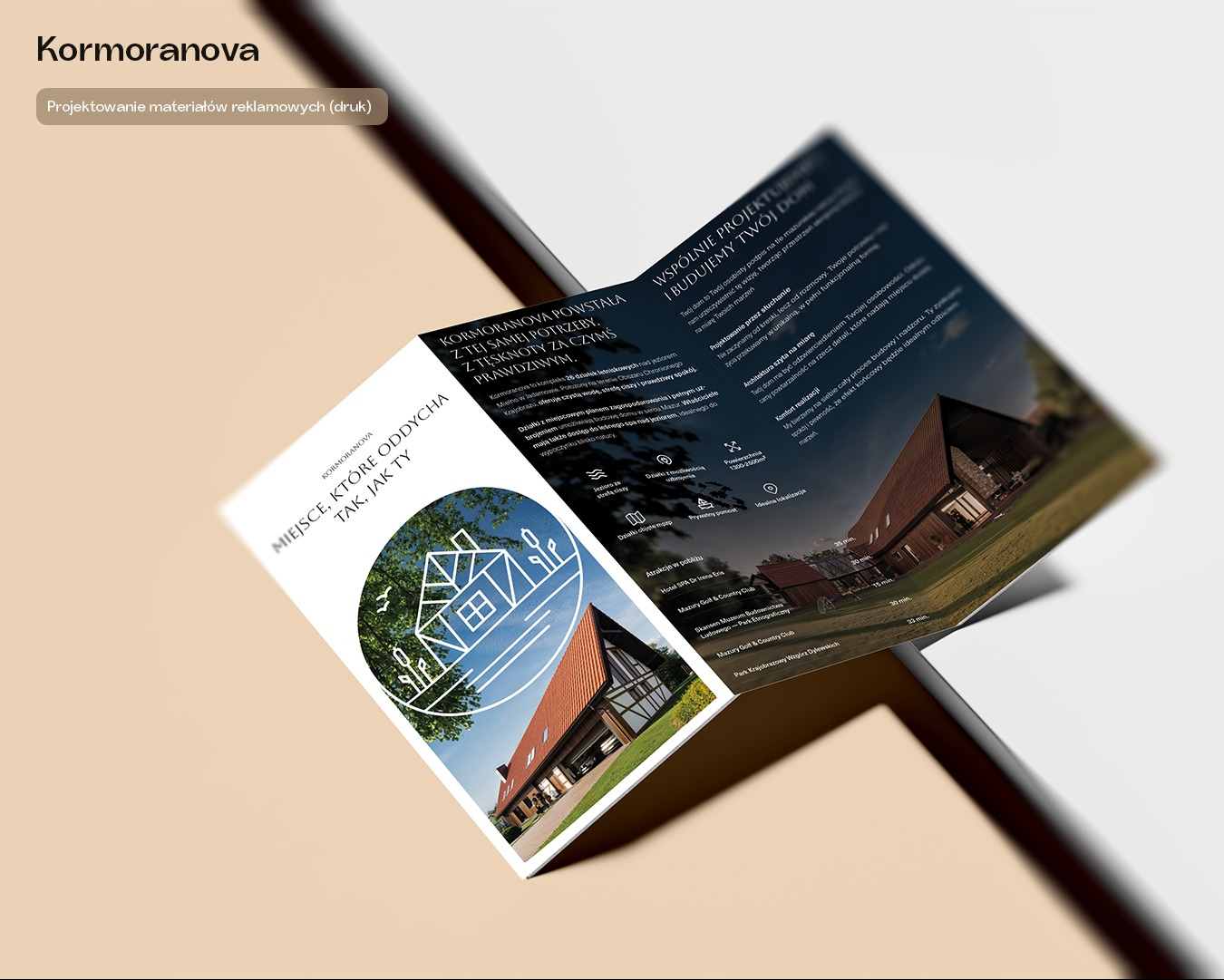 Rozłożona broszura reklamowa Kormoranova z grafiką domu i tekstem 'Miejsce, które oddycha, tak jak Ty'. Widoczne informacje o działkach letniskowych i architekturze.