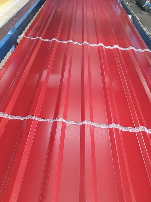 Czerwona blacha trapezowa z zabezpieczeniem transportowym, widok z góry, ukazujący profil i kolor. Idealna na pokrycie dachu lub elewacji.