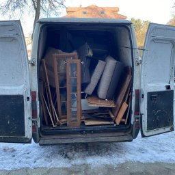 M&W Transport - Otwarty furgon wypełniony meblami i elementami wyposażenia wnętrz, przygotowany do transportu. Widoczne drzwi, okna i fragmenty sof. Zima na zewnątrz.