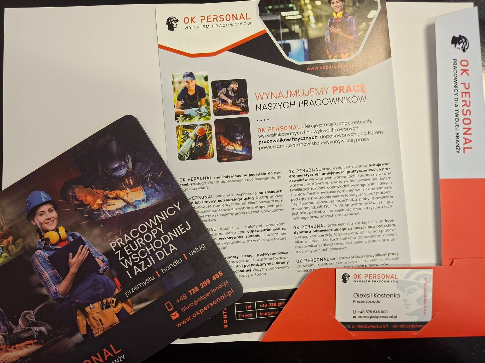 Materiały reklamowe agencji rekrutacyjnej OK Personal: ulotka z ofertą wynajmu pracowników fizycznych z Europy Wschodniej i Azji, wizytówka prezesa.