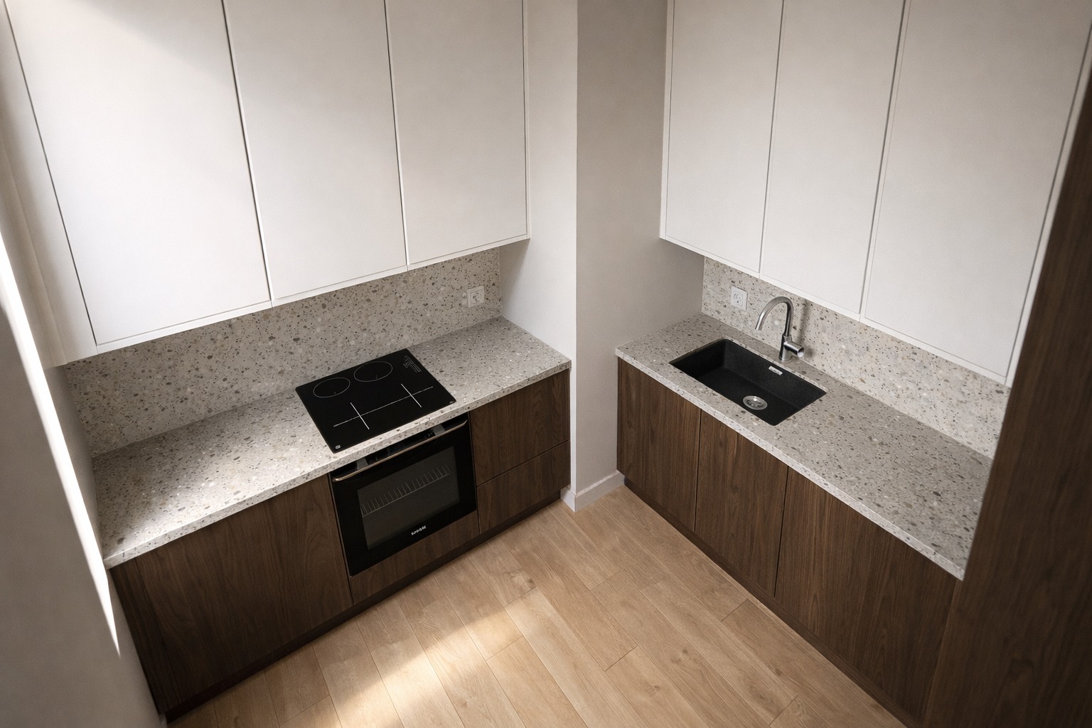 Nowoczesna kuchnia z białymi szafkami, drewnianymi frontami i blatem z lastryko. Widok z góry ukazuje płytę indukcyjną, piekarnik i czarny zlew.