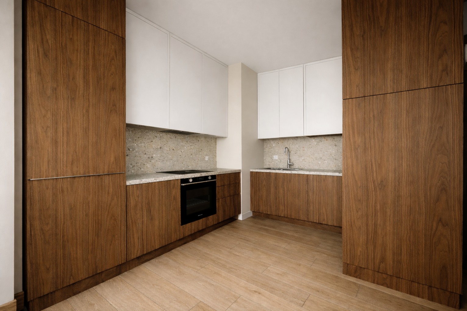 Nowoczesna kuchnia z drewnianymi szafkami dolnymi i białymi górnymi, wykończona blatem z lastryko. Uwagę przykuwa minimalistyczny design i ciepłe oświetlenie.