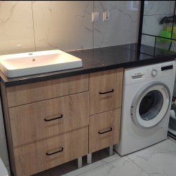 DZIAŁAK BOGDAN KARPENTER FIRMA WIELOBRANŻOWA - Nowoczesna łazienka z szafką pod umywalkę z frontami w kolorze drewna, czarnym blatem i pralką Bosch. Kabina prysznicowa z czarnymi profilami.