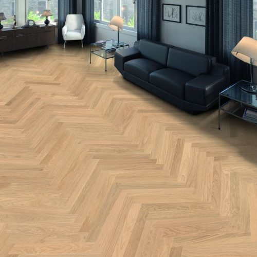 Salon z parkietem ułożonym we wzór jodełki francuskiej. Jasne drewno, czarna skórzana sofa, szklane stoliki kawowe. Nowoczesne wnętrze z zasłonami w kolorze granatowym.