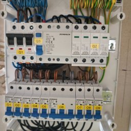 Denys Modelskyi 'DKSSystem' - Rozdzielnica elektryczna Schrack z bezpiecznikami oznaczonymi Q1, Q2, Q3 i B16/1 od 01 do 09, z podłączonymi przewodami w różnych kolorach. Widok z bliska.