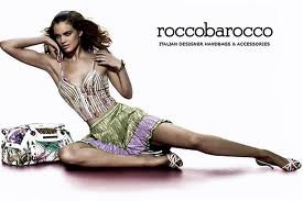 Modelka w letniej stylizacji pozuje z torebką marki roccobarocco, widoczny zegarek na nadgarstku.