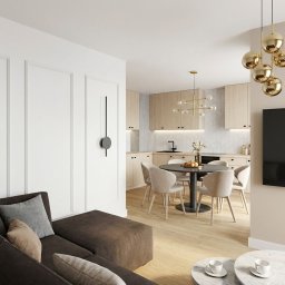 Projekty Architektury Paweł Kozioł - Jasne wnętrze pokoju dziennego z aneksem kuchennym. Minimalistyczny design, drewniane podłogi, okrągły stół i nowoczesne oświetlenie. Widoczny fragment sofy.