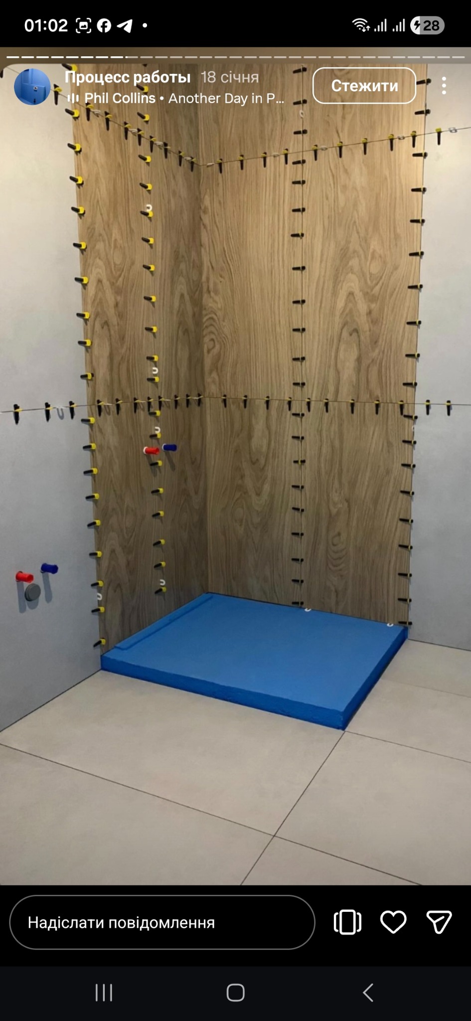 Montaż płytek imitujących drewno w kabinie prysznicowej. Widoczne poziomowanie z użyciem klipsów i klinów. Niebieski brodzik. Przygotowanie do fugowania.