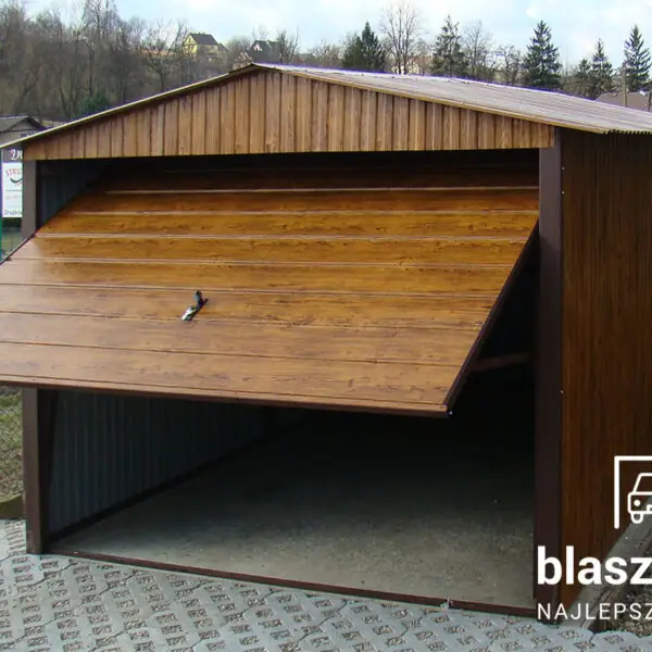 Otwarty garaż z blachy drewnopodobnej, z widoczną konstrukcją i podłożem. Brama segmentowa podniesiona, ukazująca wnętrze. Tło stanowią drzewa i zabudowania.